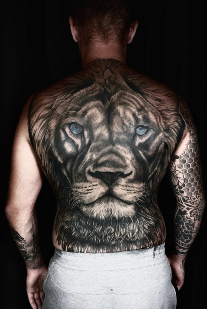 Realpain Tattoo: Rückenfüllender Löwe mit blauen Augen